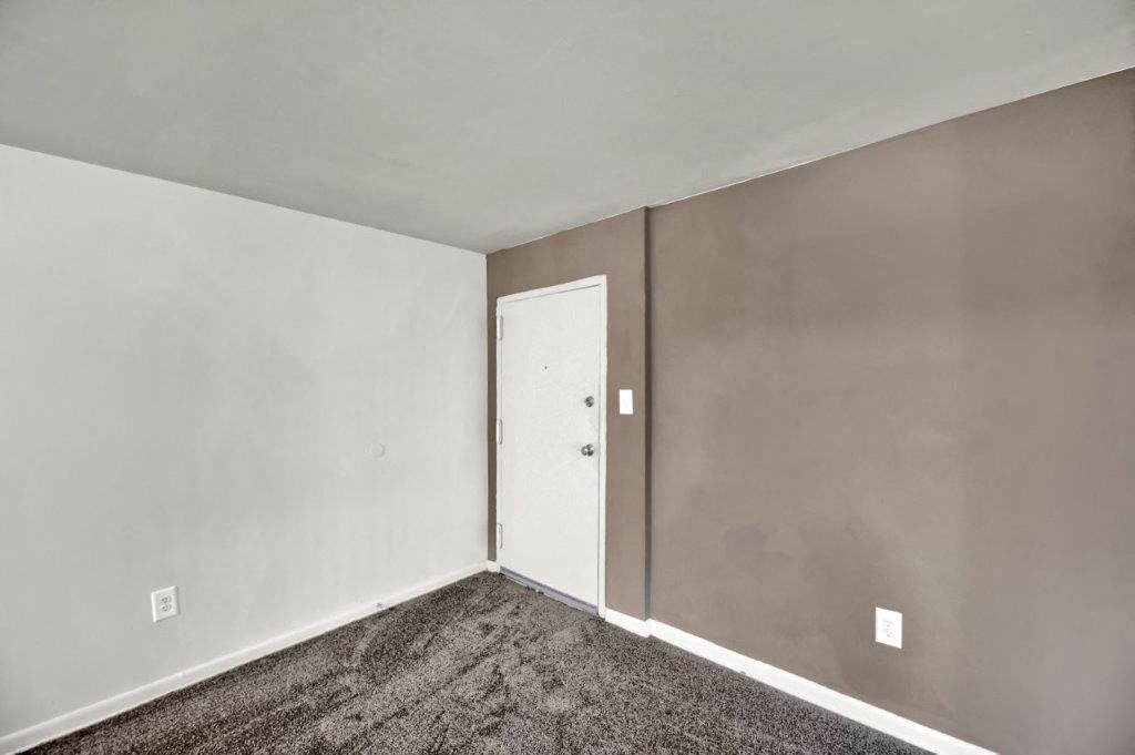 the living room of an empty house with a door